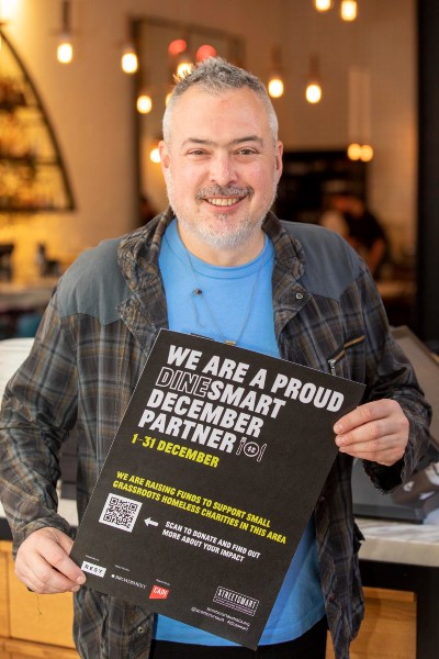 Simon Denton holding DineSmart poster